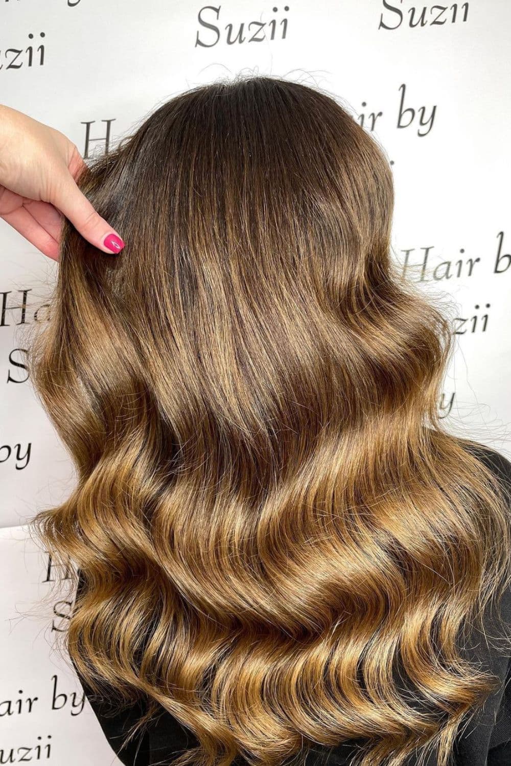 A woman with long wavy brown blonde balayage ombre.
