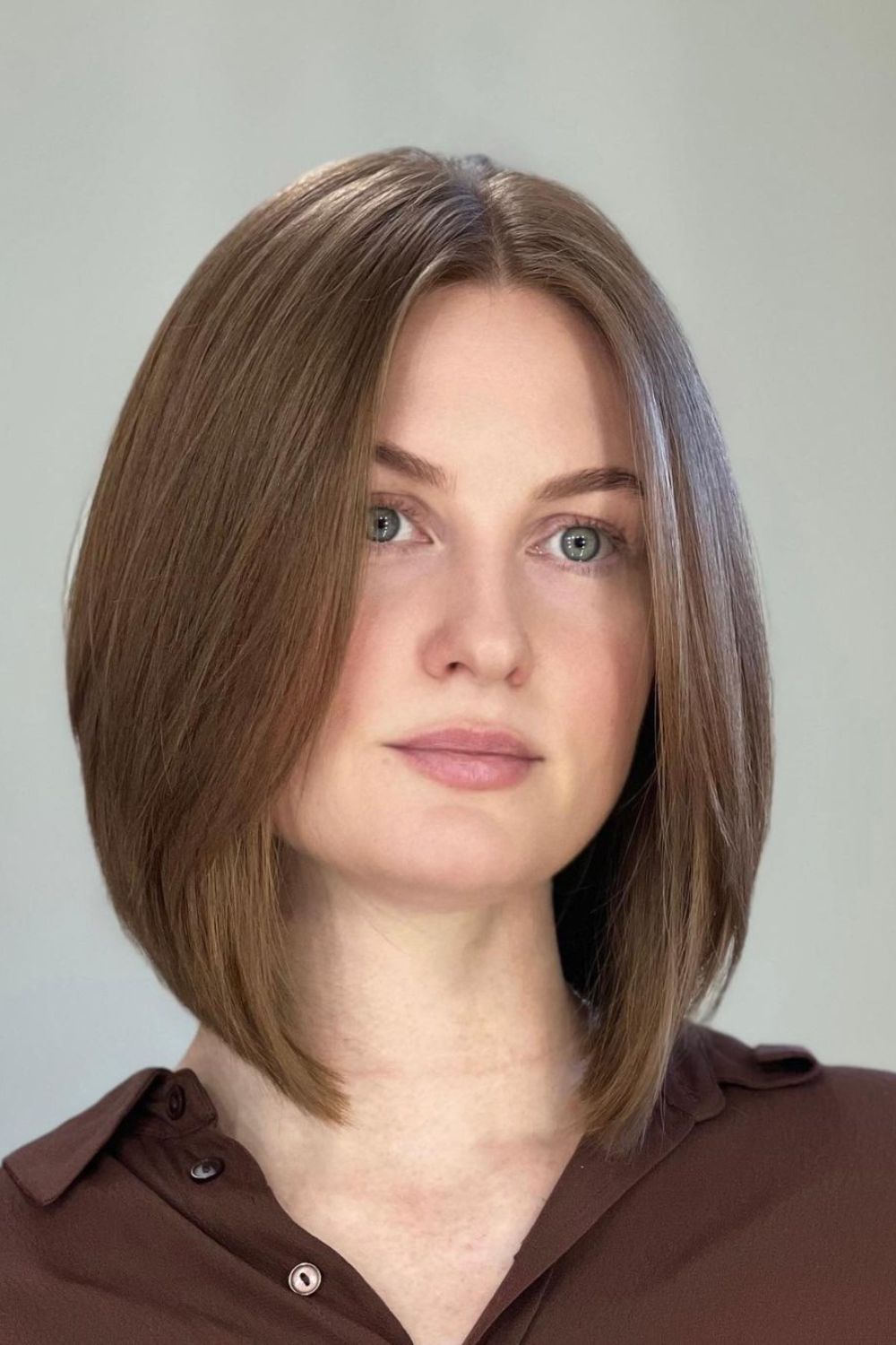 A woman with a light brown center-parted bob cut.