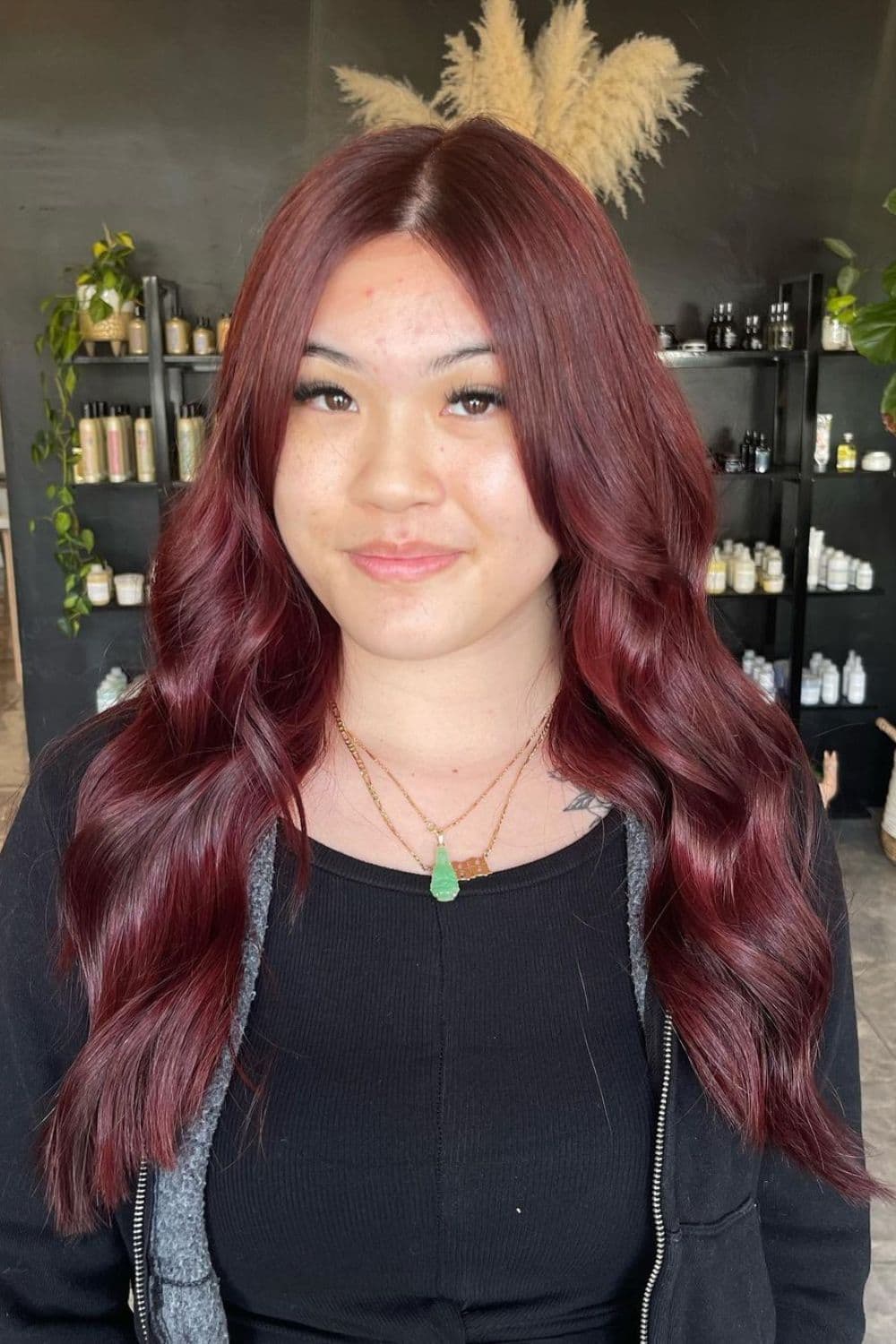 A woman with long wavy cherry cola red hair.