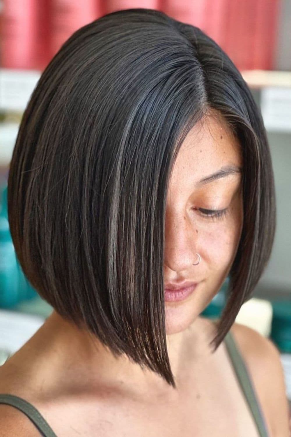 A woman with a chin-length bob with deep side part.