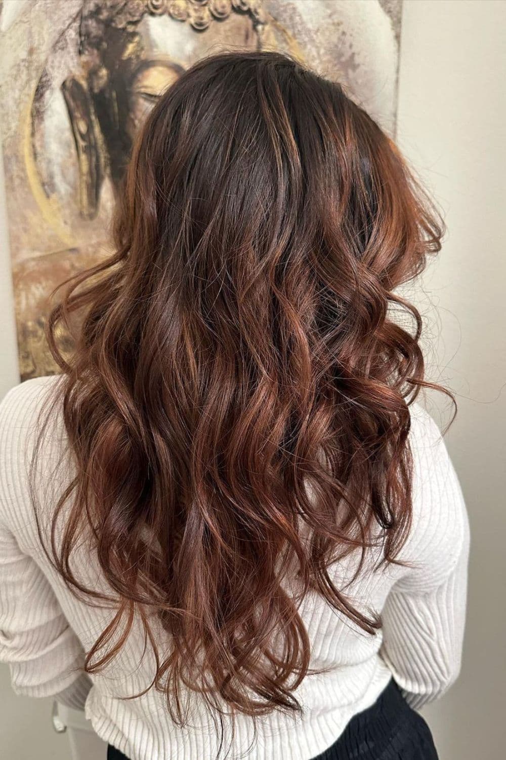 A woman with long chocolate brown balayage with curls.