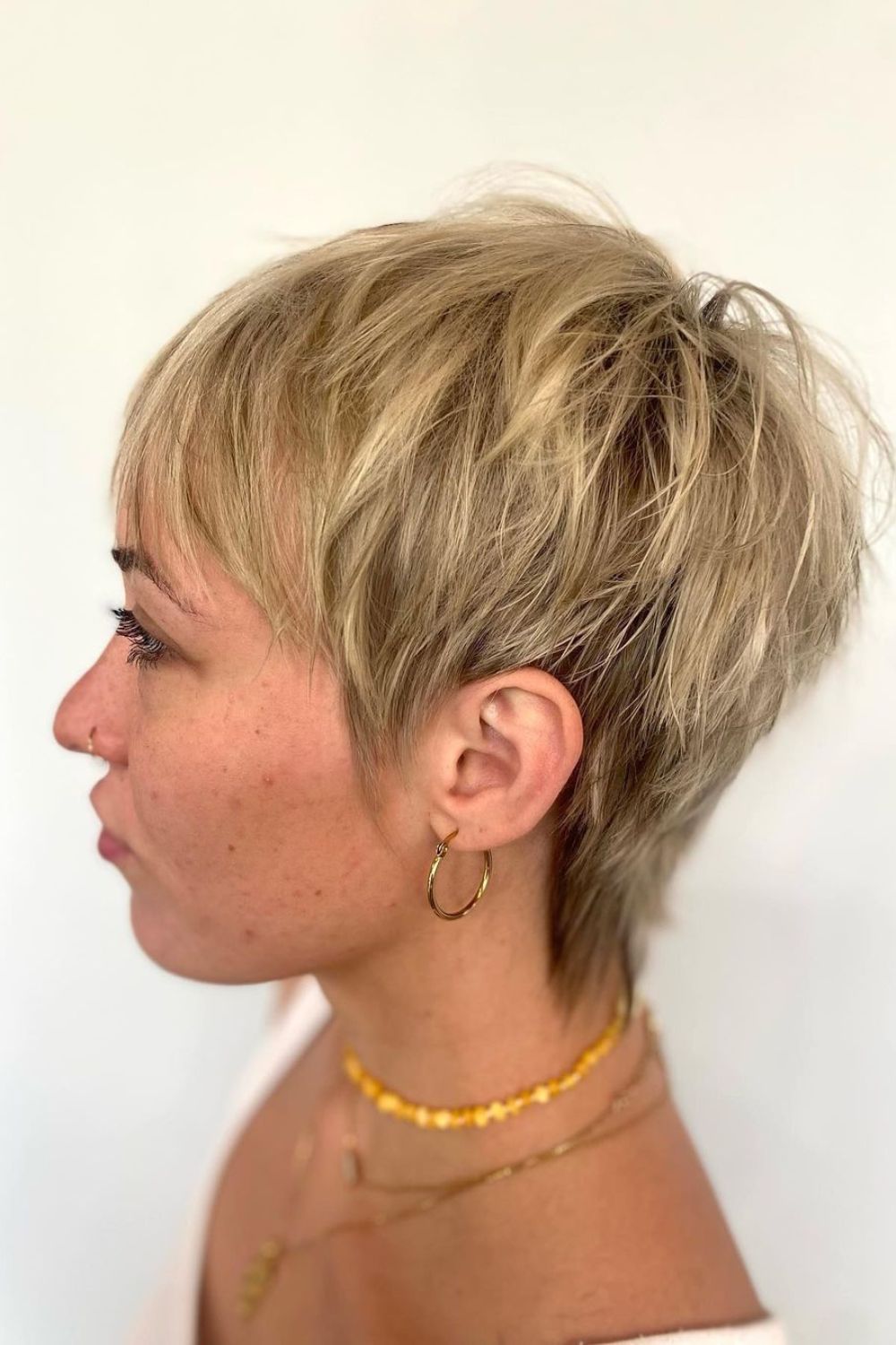 A woman with a blonde choppy textured pixie cut.
