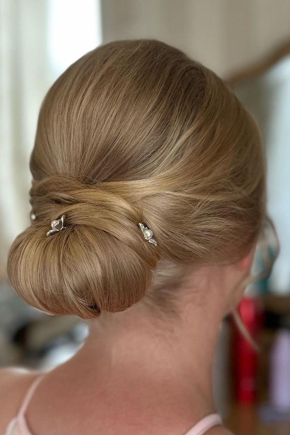 A woman with a blonde classic chignon.