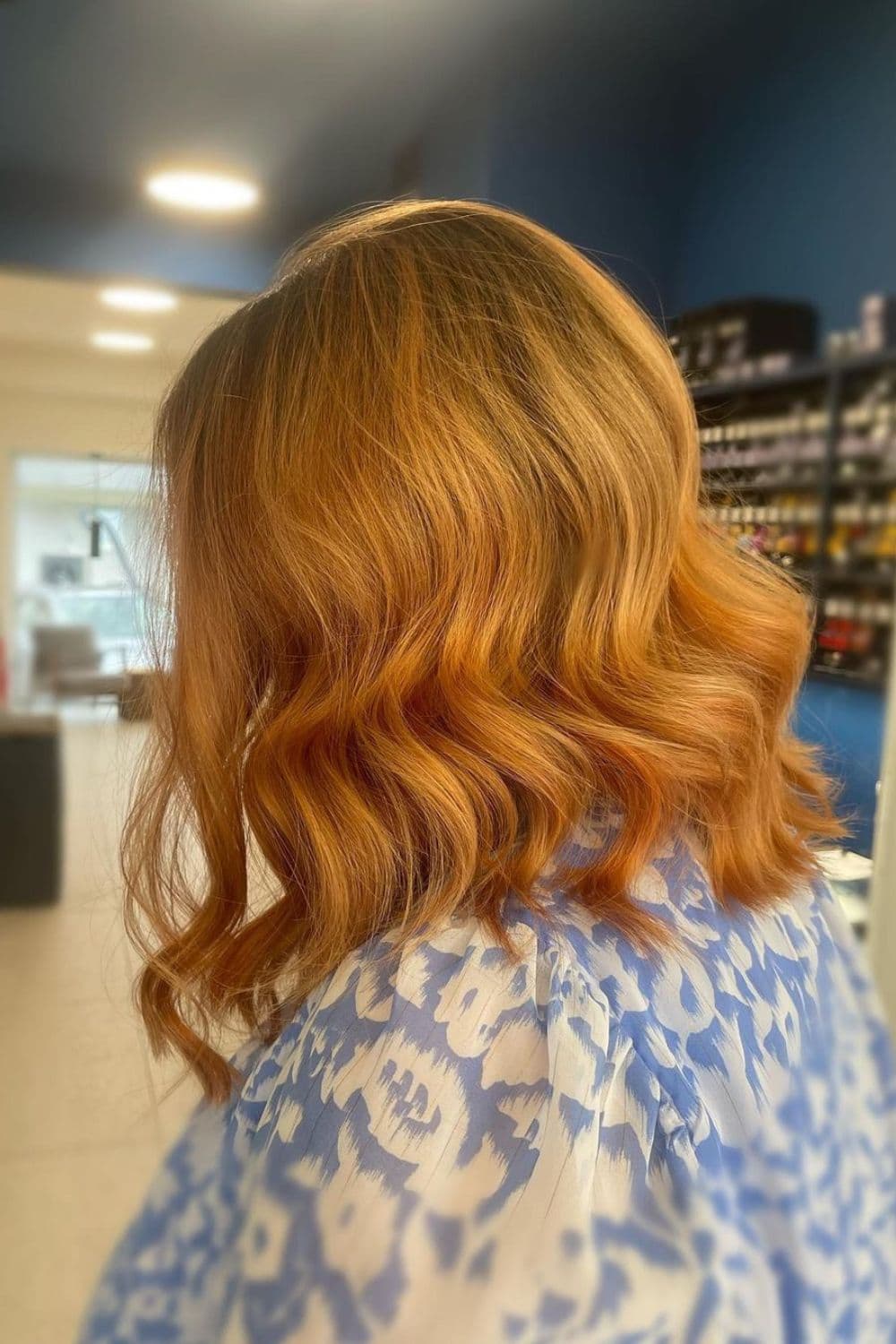 A woman with a copper blonde lob bob with waves.