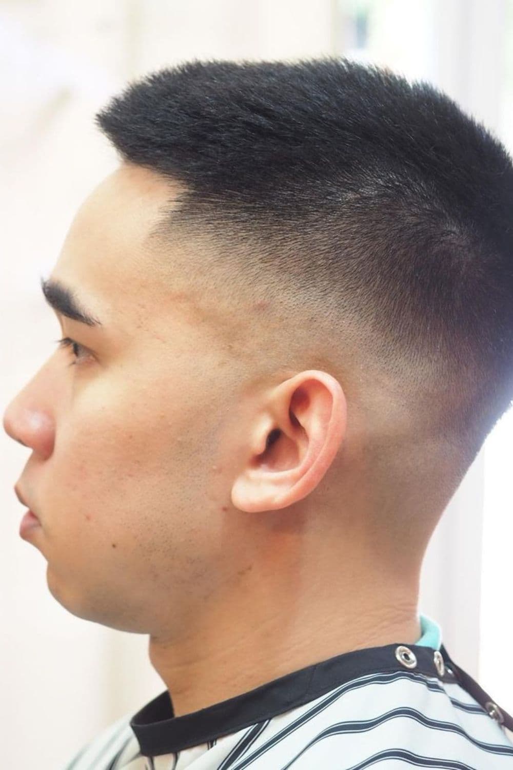 Side view of a man with a crew cut high and tight taper fade.