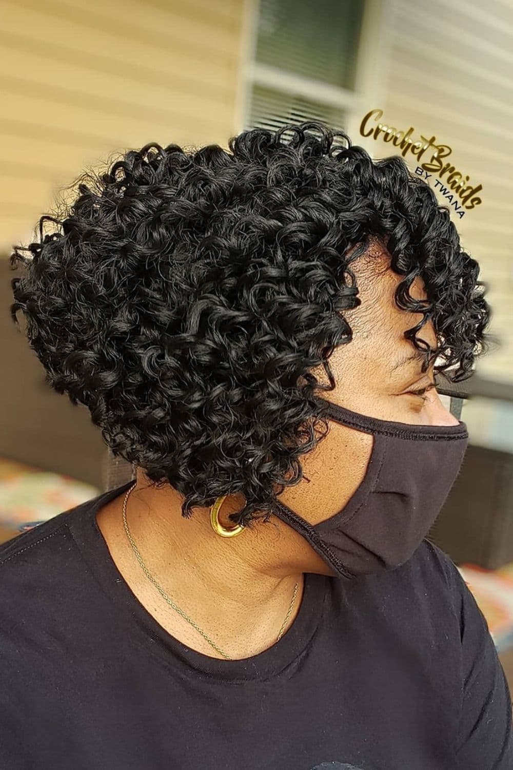 A woman wearing a brown face mask with a crochet braid lob.