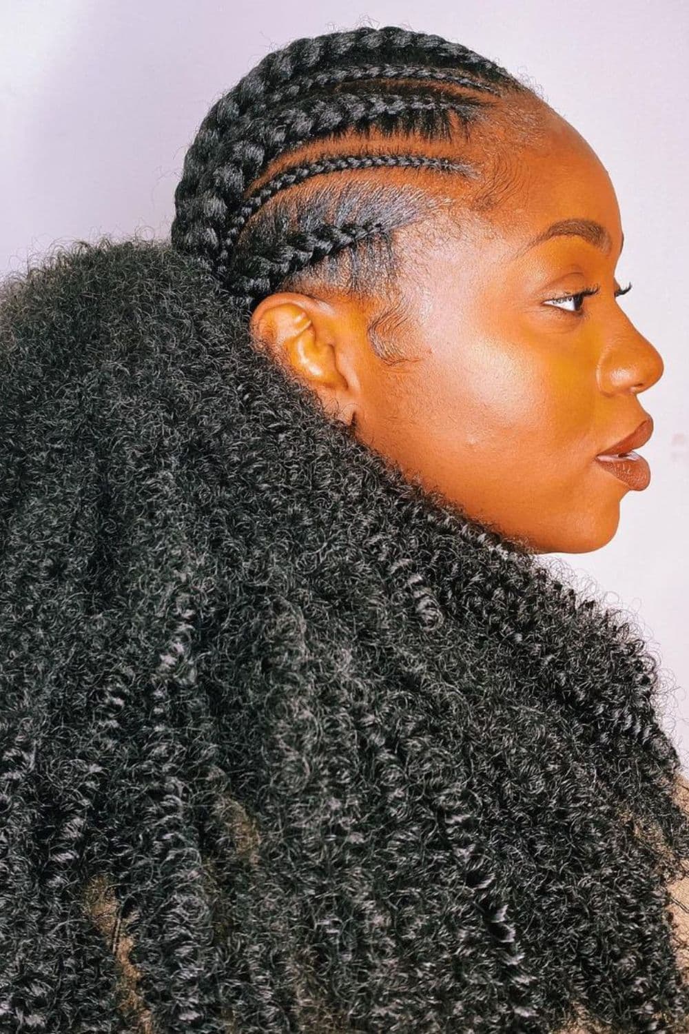 A woman with a crochet braid low ponytail.