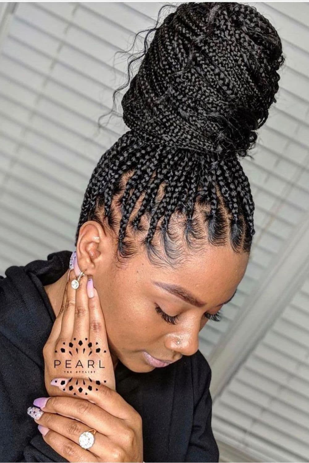 A woman with a black crochet braid top knot.