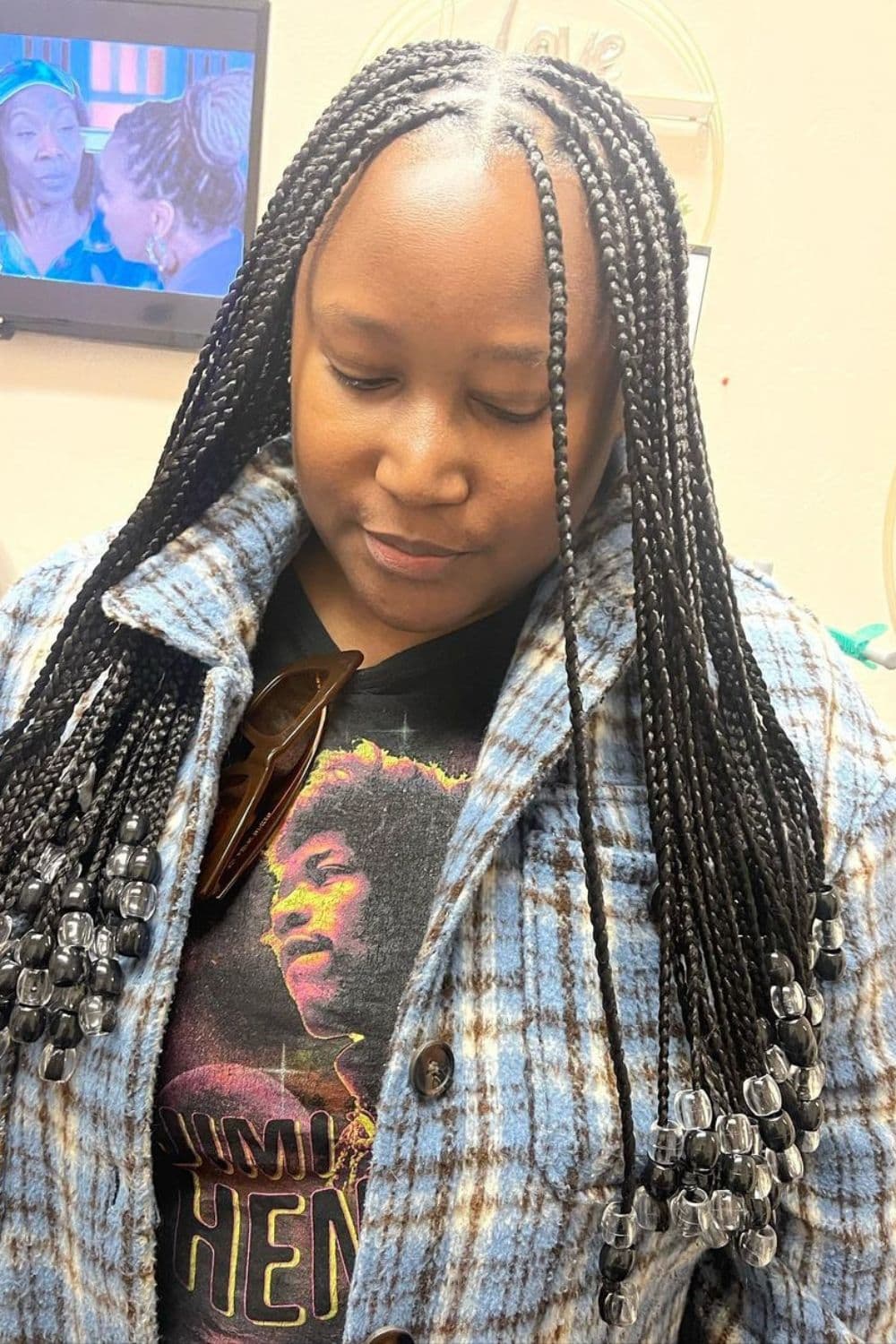 A woman with black crochet braids with beads.