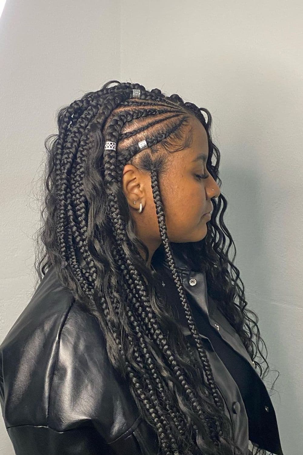 A woman with black crochet braids with silver cuffs.