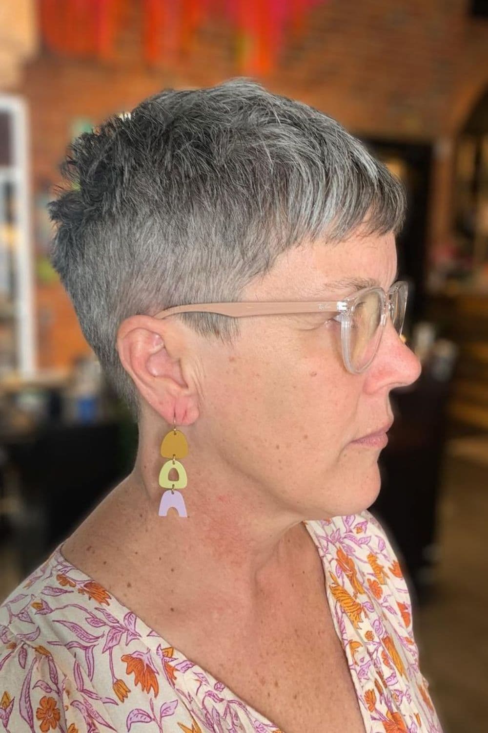 A woman with a gray cropped pixie cut.
