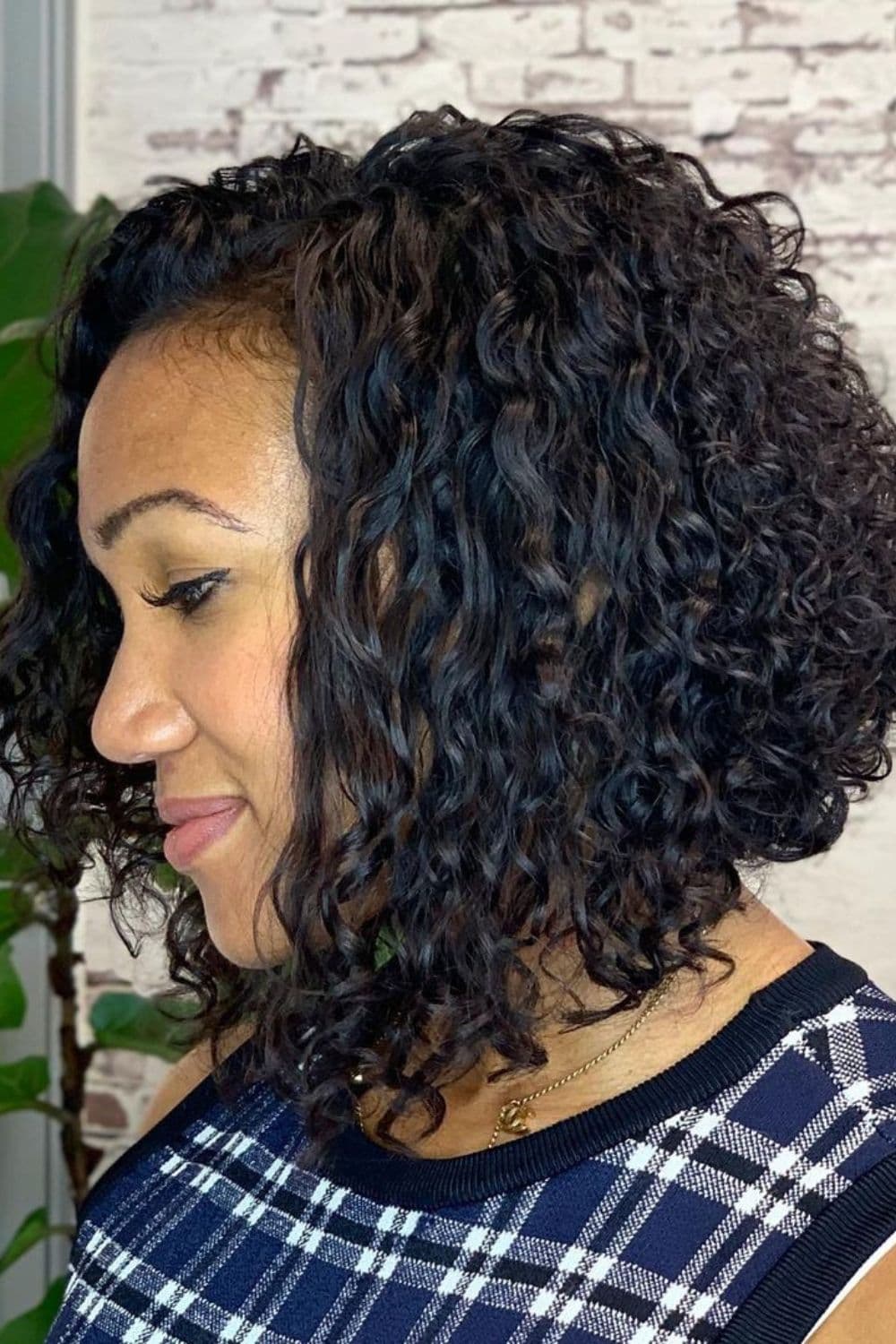 A woman with a black curly angled bob cut.
