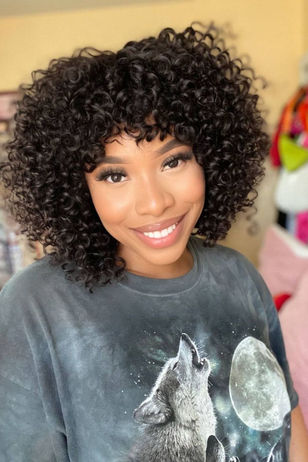 A woman with a curly bob with curly bangs.