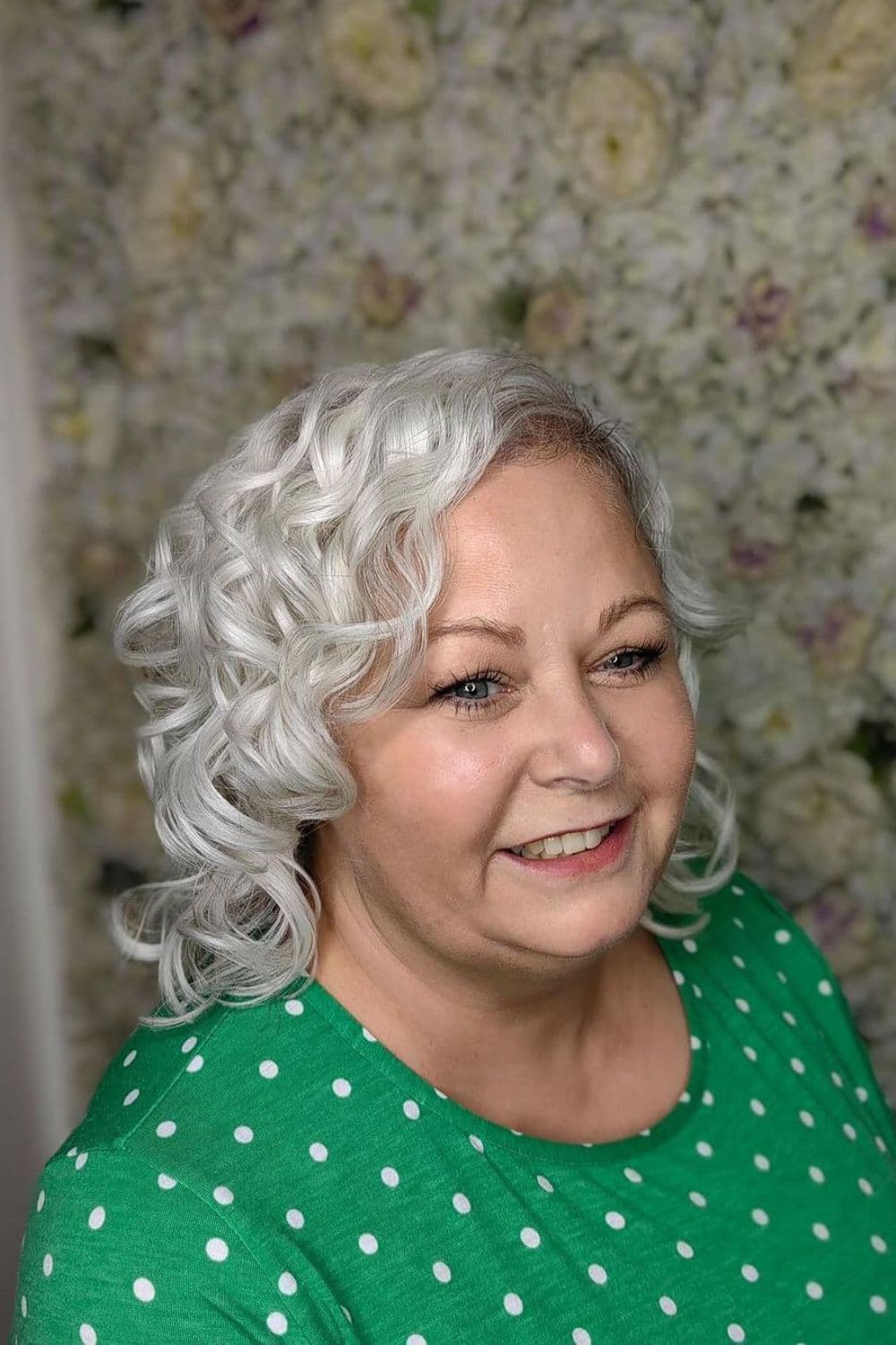 A woman with curly silver bob hair.