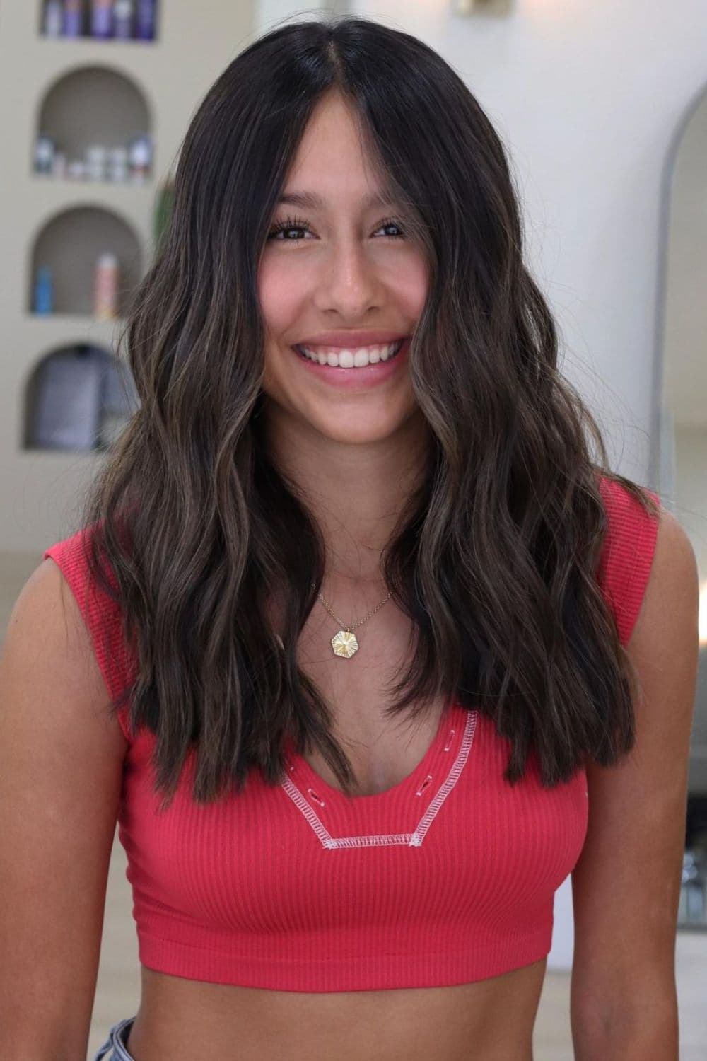 A woman with medium length dark brown balayage hair.