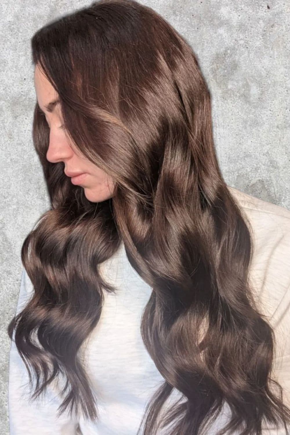 A woman with long glossy dark brown quick weave.