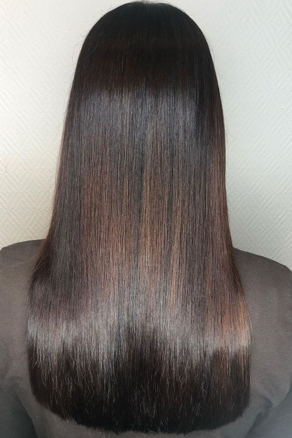A woman with long straight dark cinnamon hair.