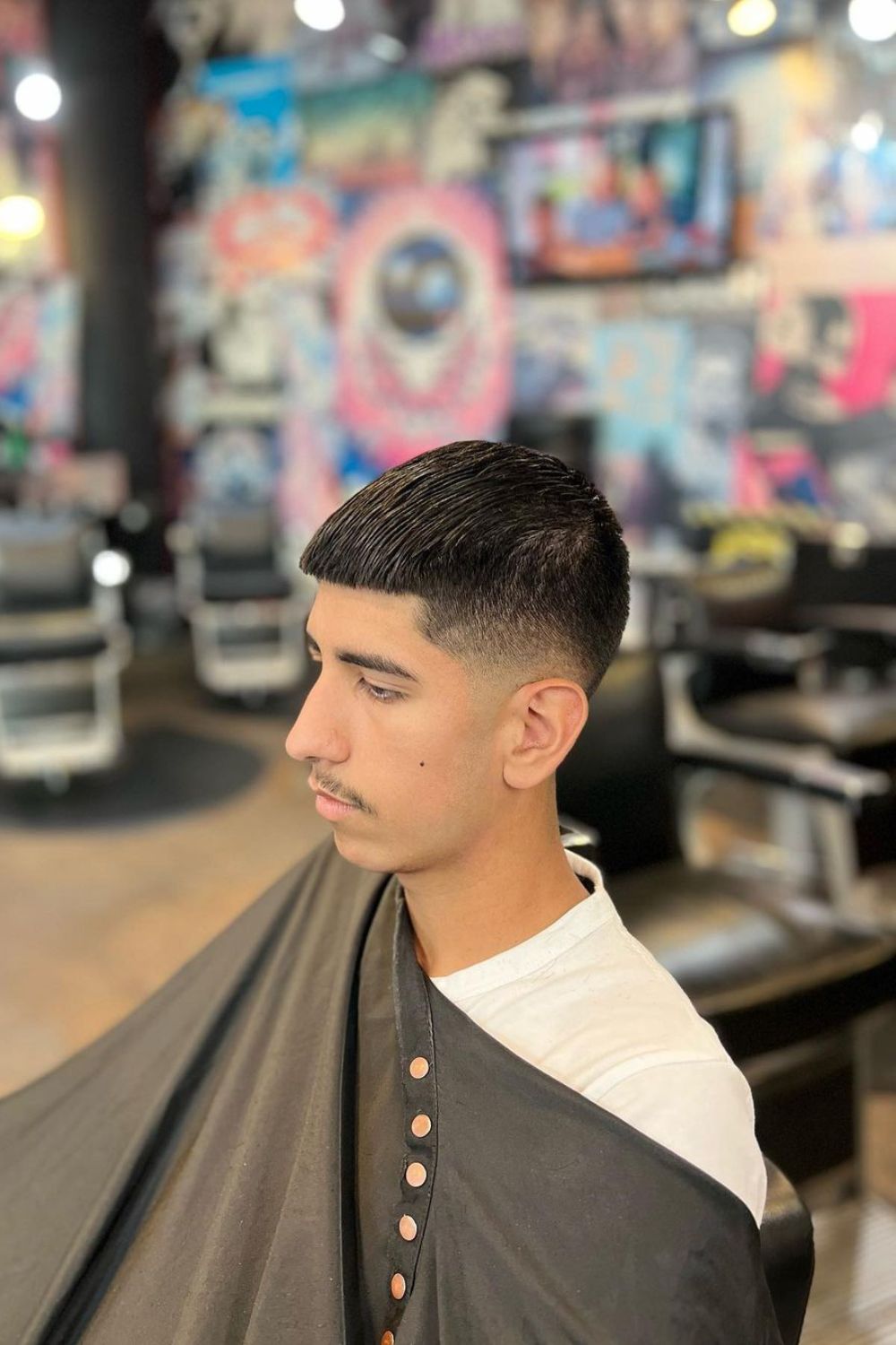 A man with an Edgar cut with low fade.