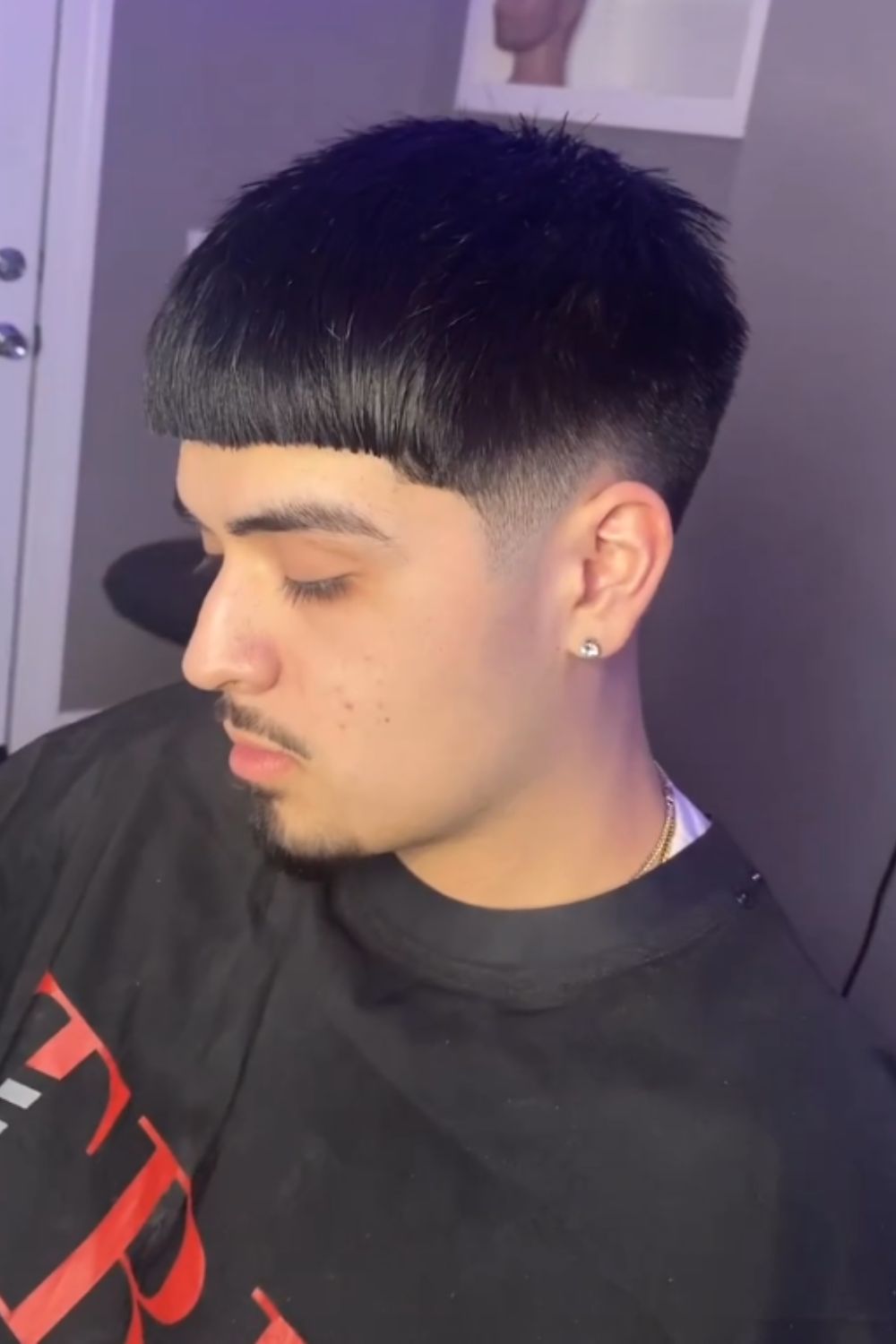 A man with an Edgar cut with low drop fade.