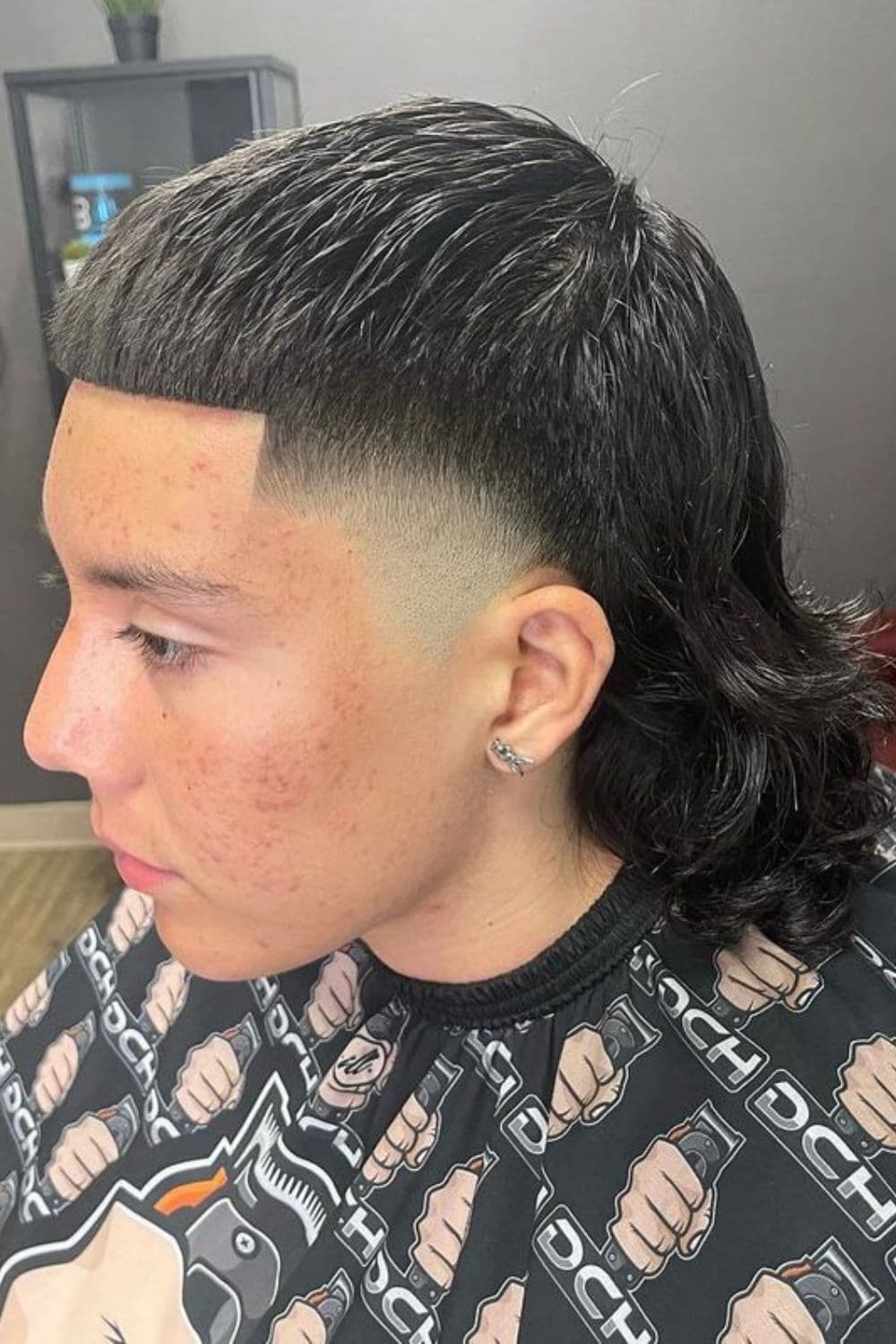 A man with an Edgar cut with a Mexican mullet.