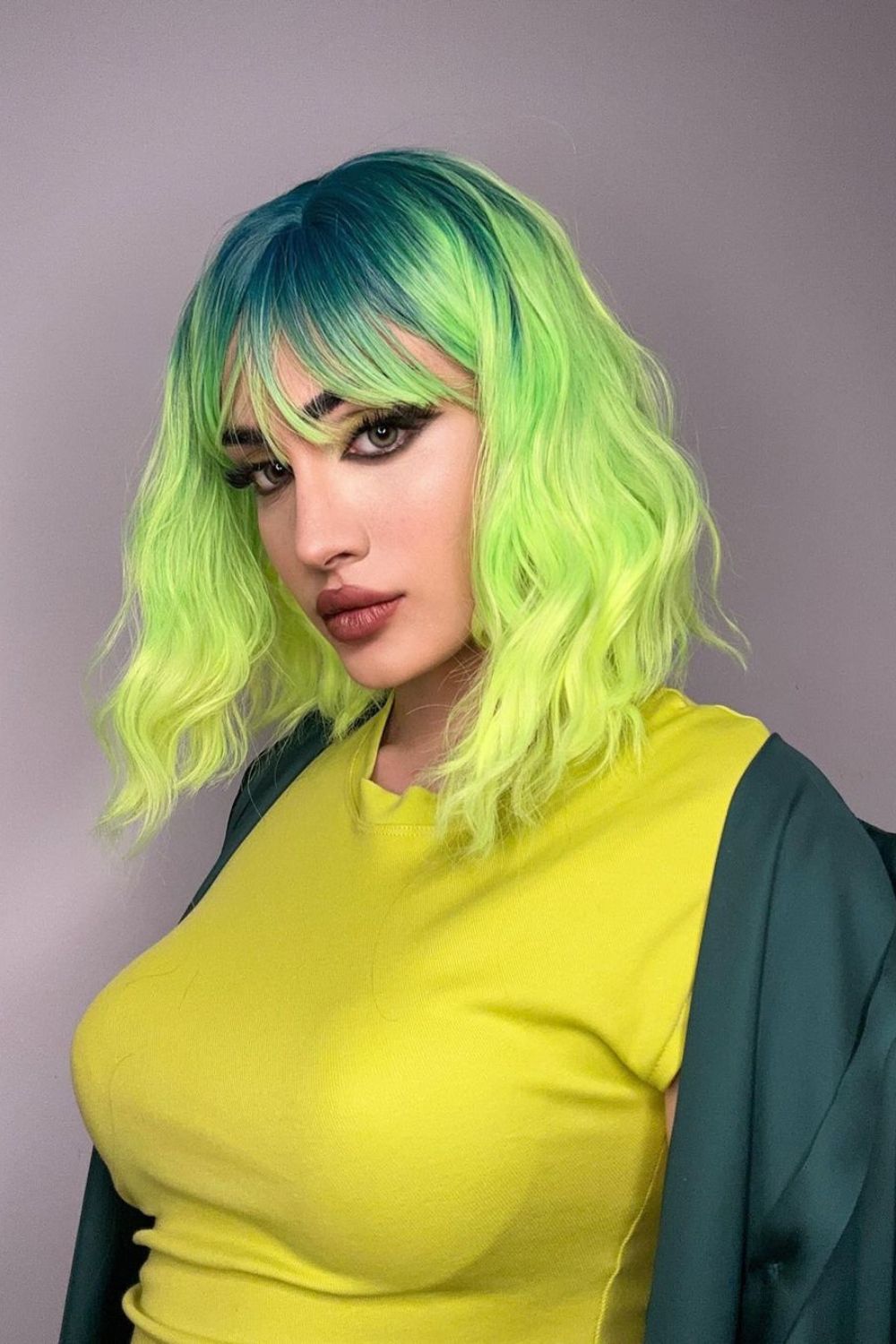 A woman with and emerald to lime green ombre hair.
