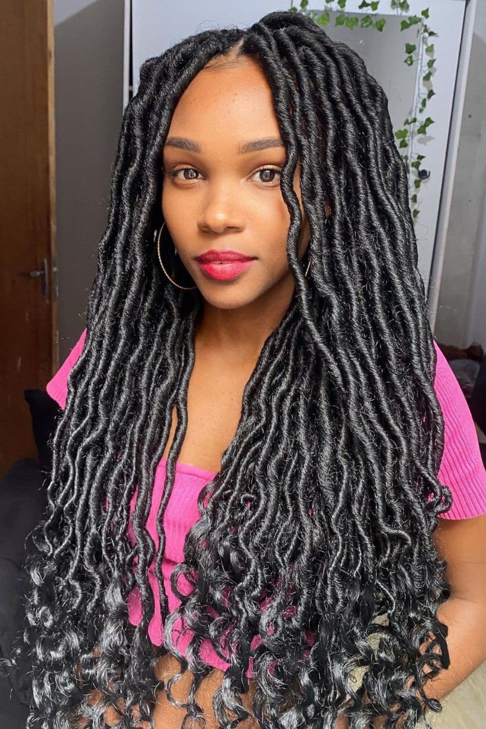 A woman with long black faux locs.