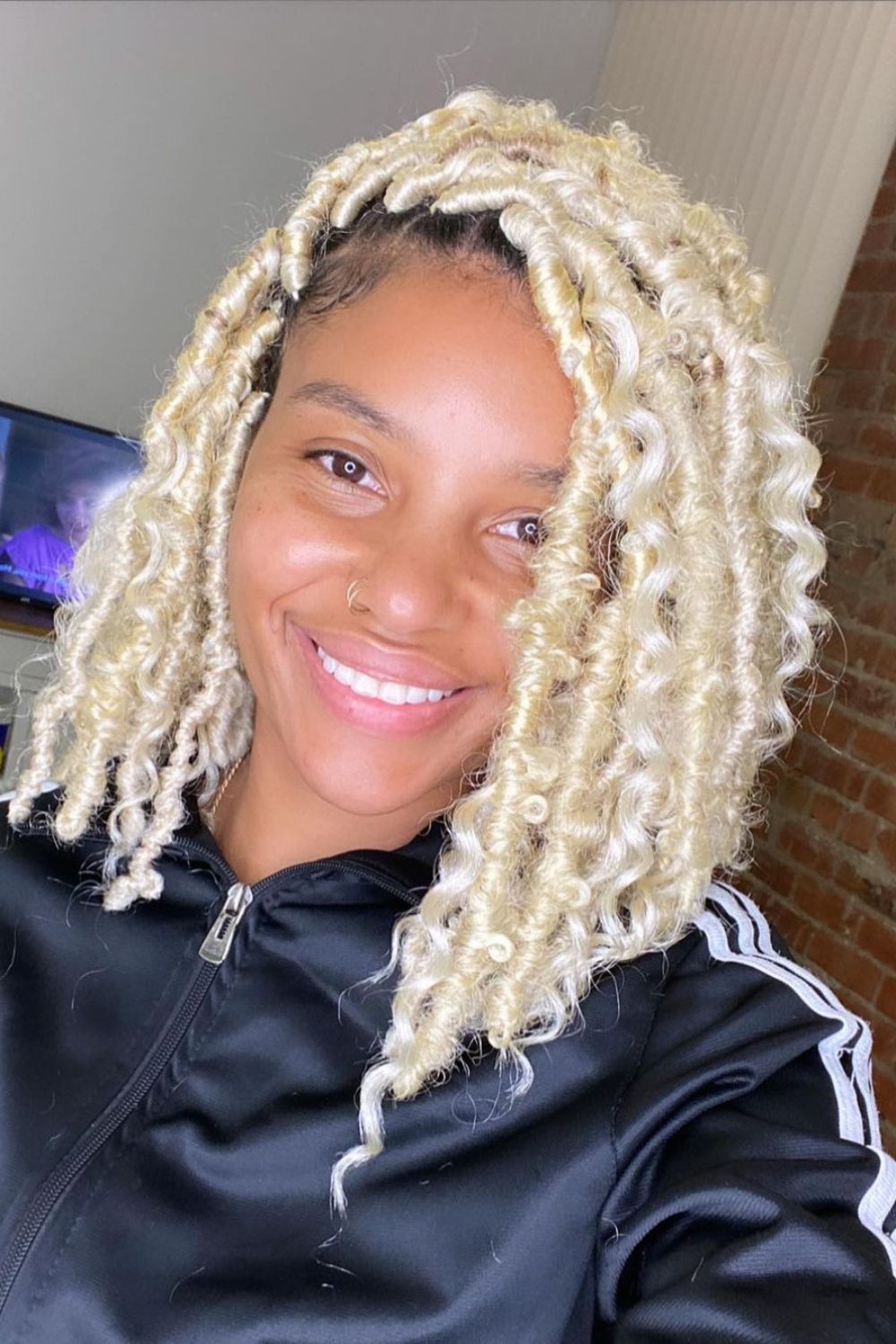 A woman with a blonde faux locs bob.