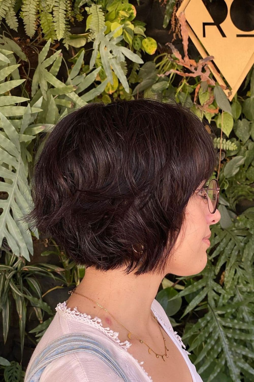 A woman with a black feathered bixie cut.