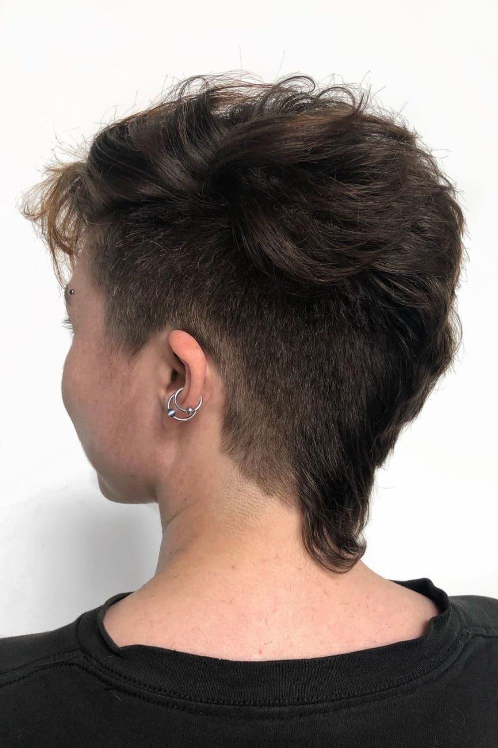 A woman with a black feathered faux hawk.