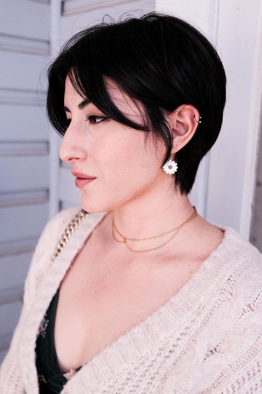 A woman with a black feathered pixie cut.
