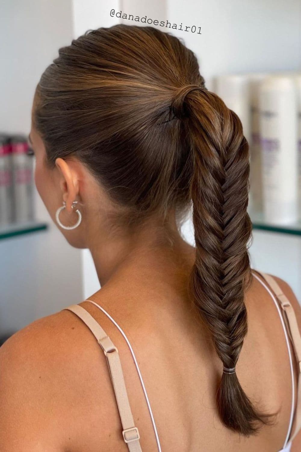 A woman with a brown fishtail braid.
