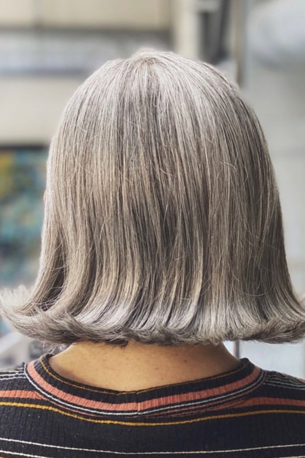 A woman with a gray flipped out lob cut.