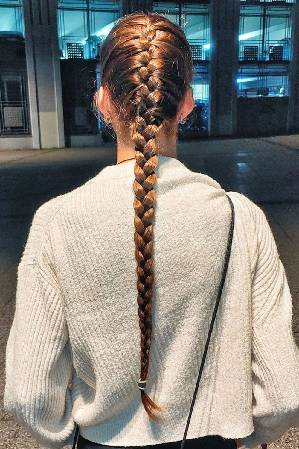 A woman with brown French braids ponytail.