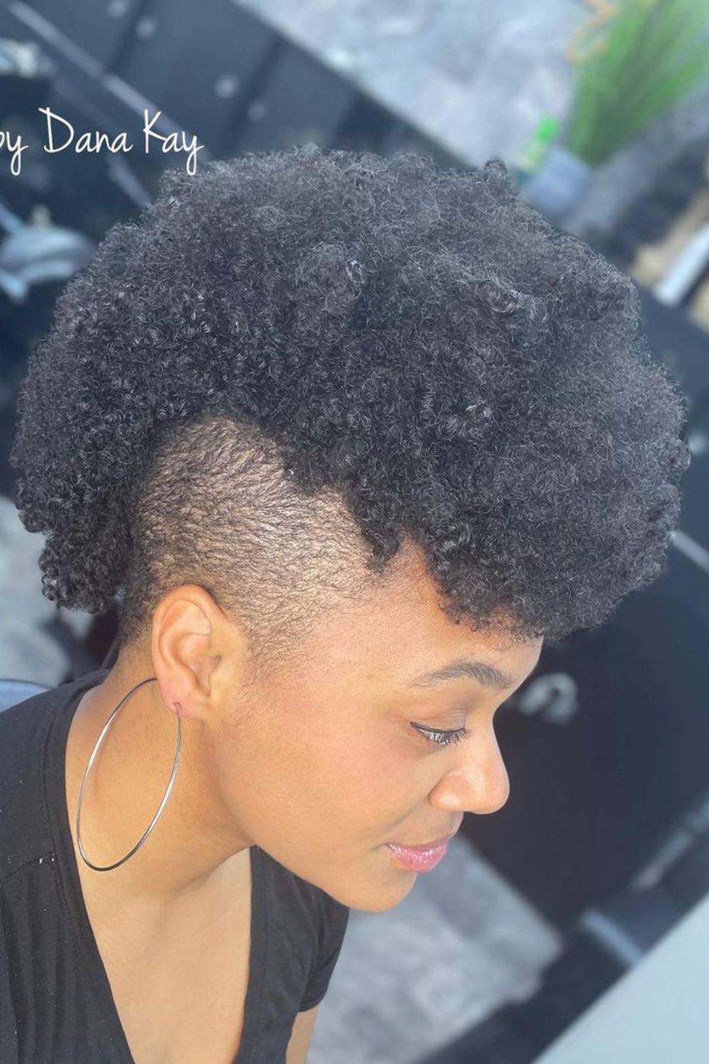 A woman with a black frohawk.