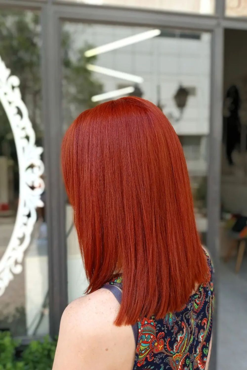A woman with medium-length, straight ginger red hair.