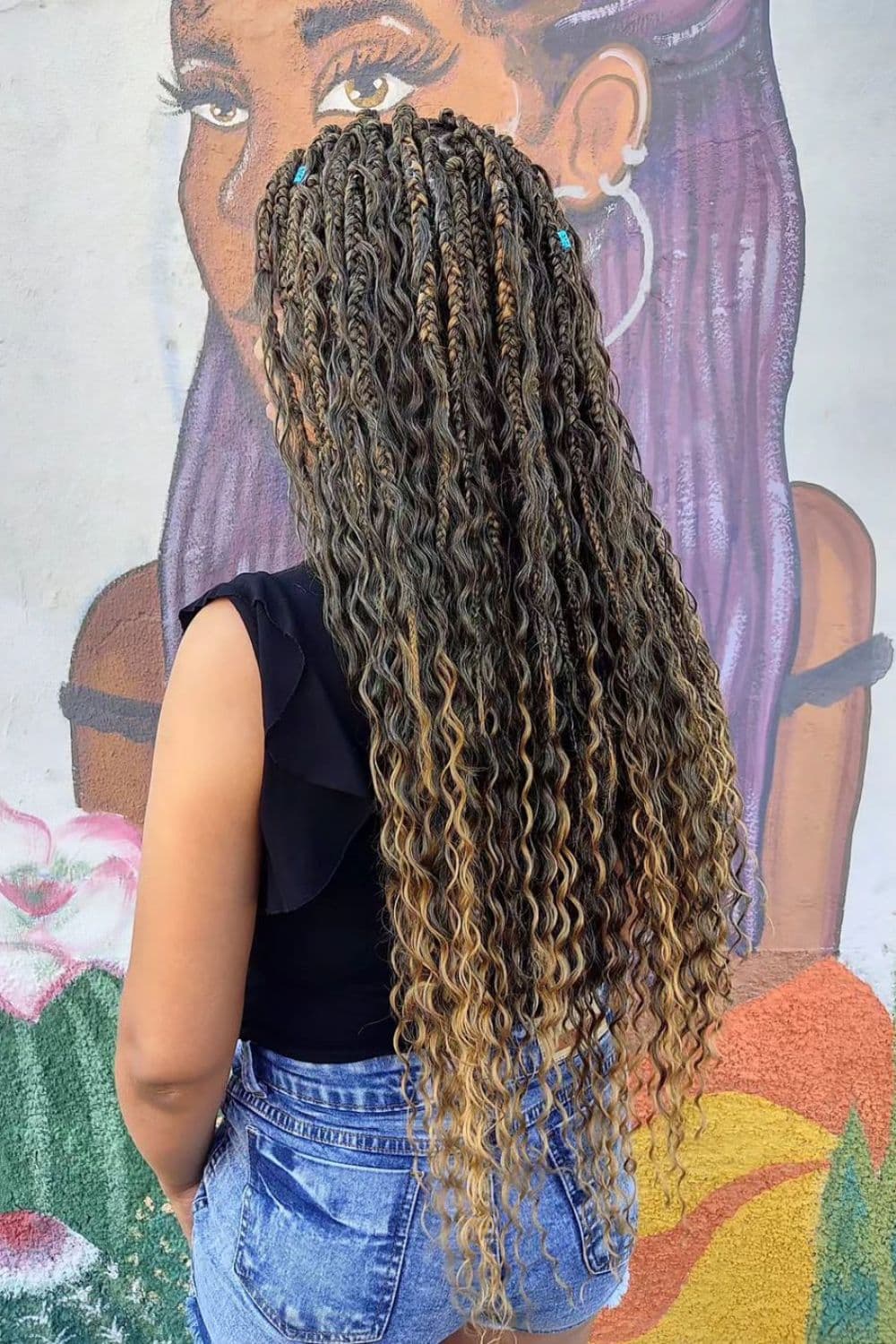 A woman with long goddess braids with highlights.