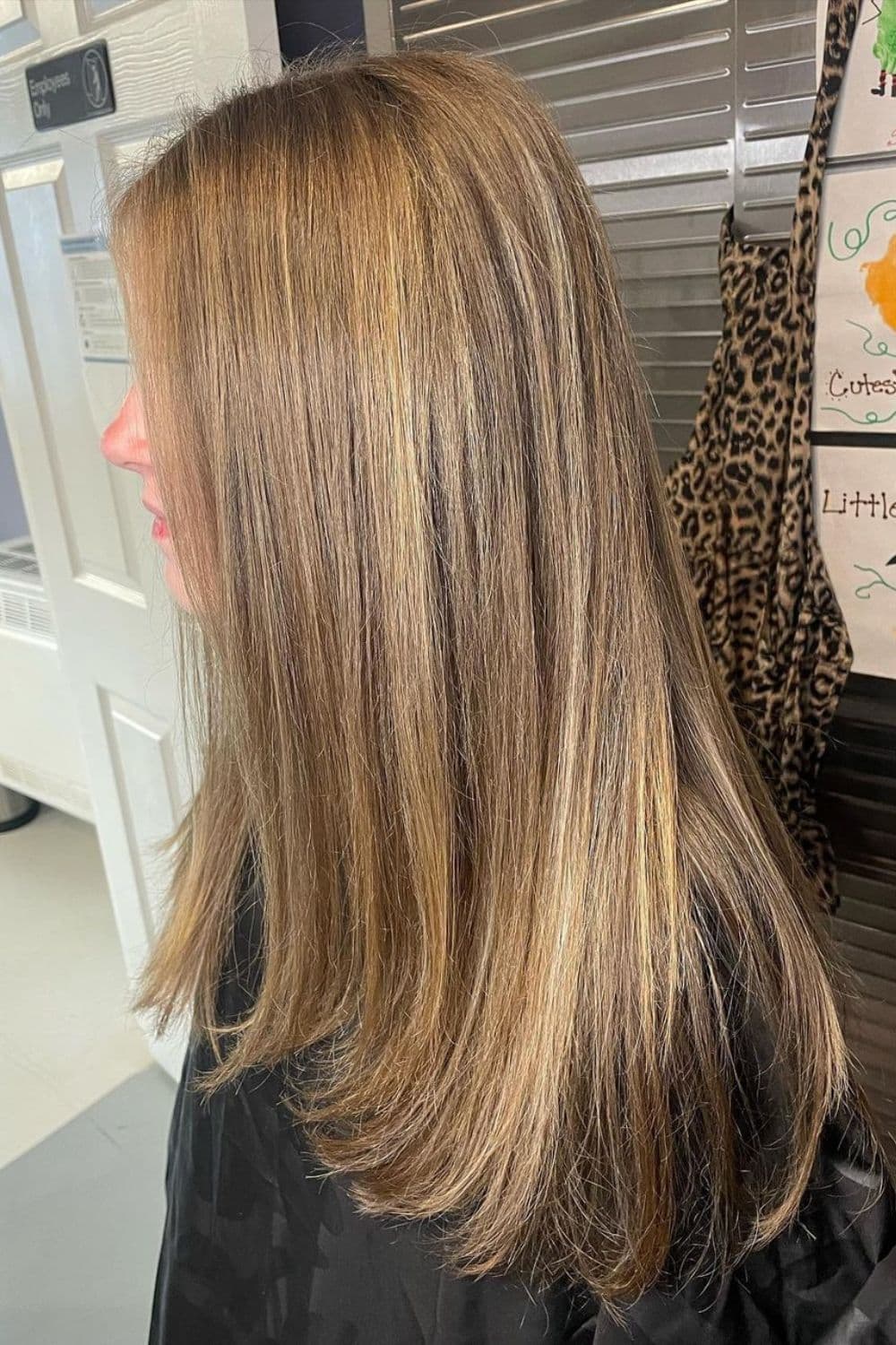 A woman with long straight golden bronde balayage.