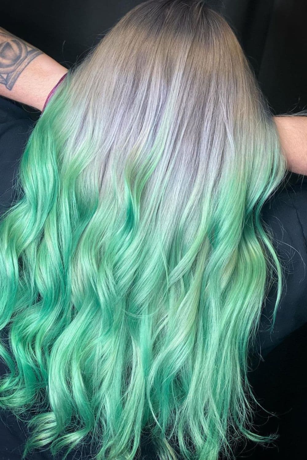 A woman with gray to mint green ombre hair.
