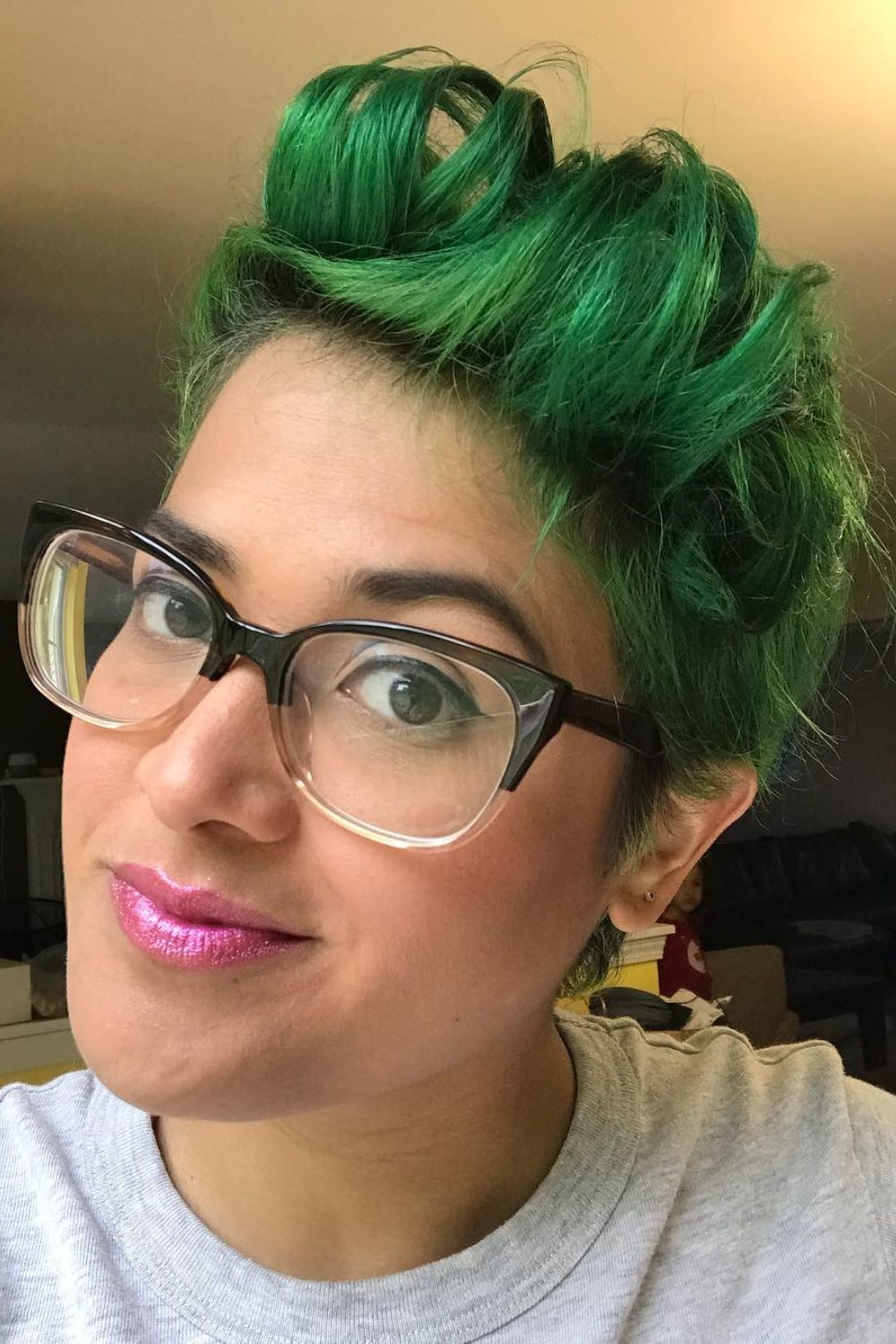 A woman wearing eyeglasses with a green faux hawk.