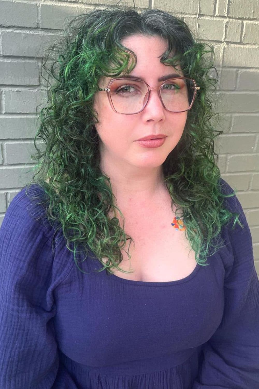 A woman with a curly green ombre hair.