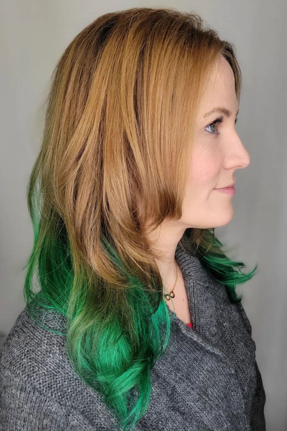 A woman with a medium-length green ombre hair.