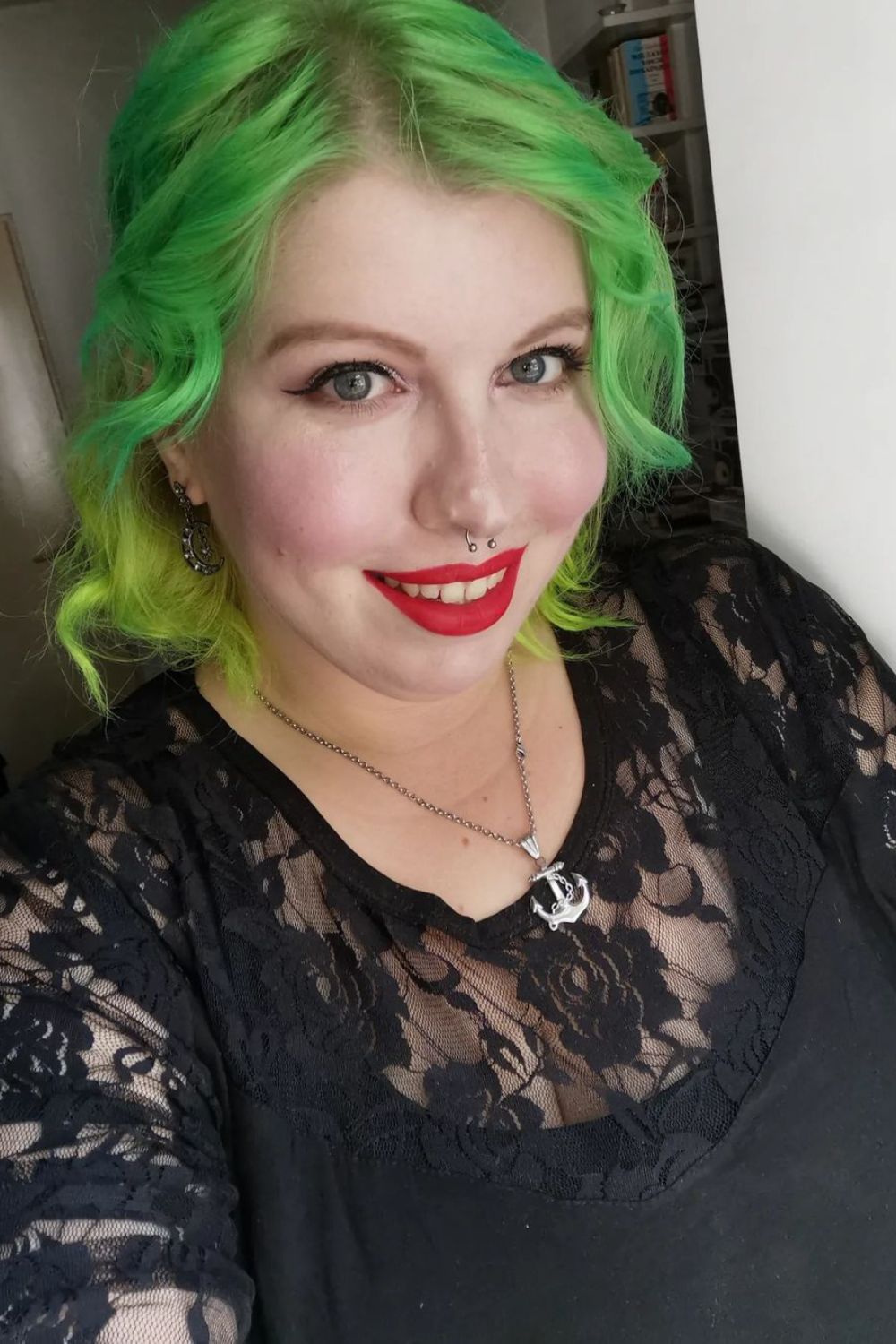 A woman with a short green ombre hair.