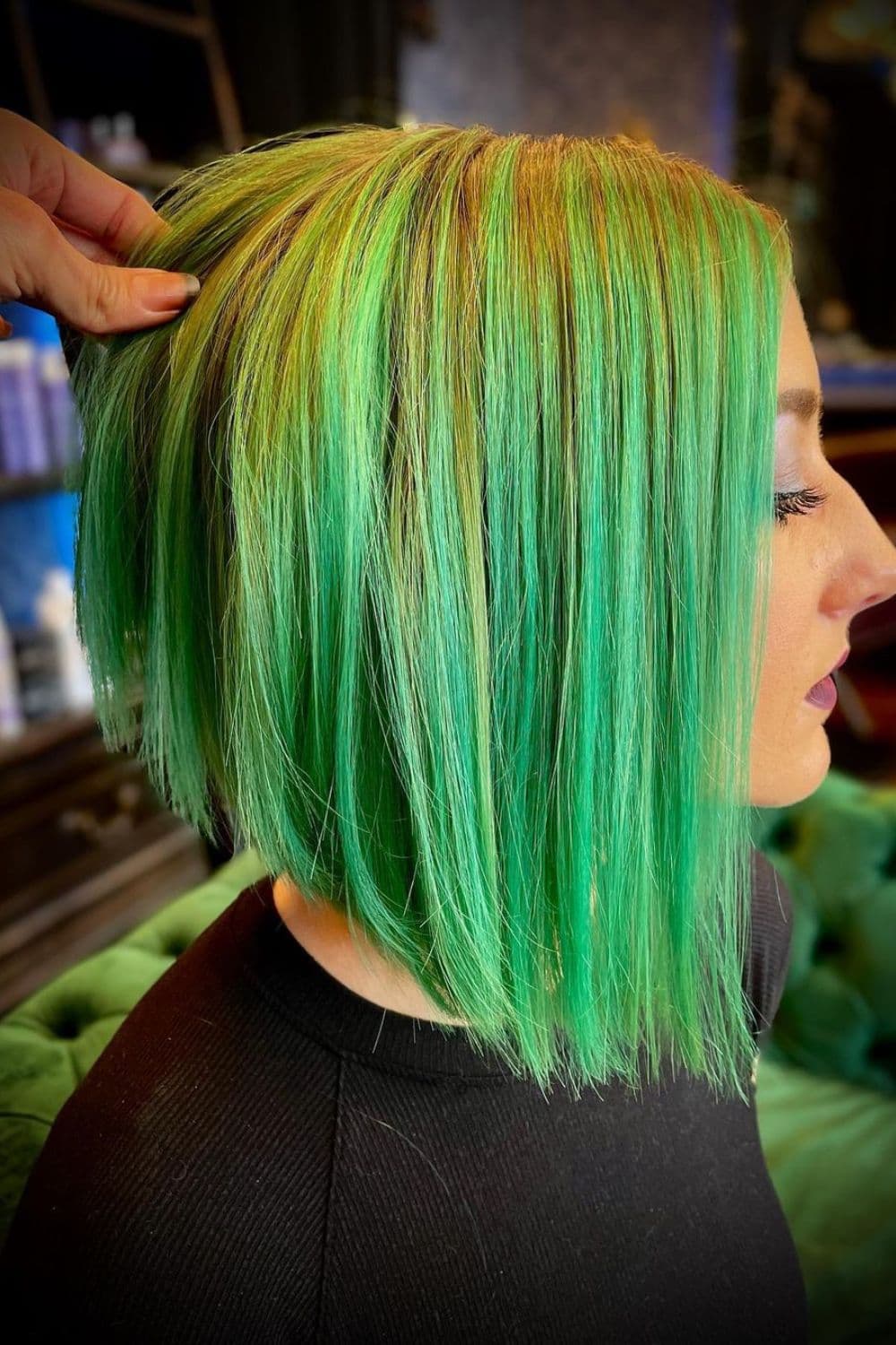 A woman with a green ombre inverse bob.