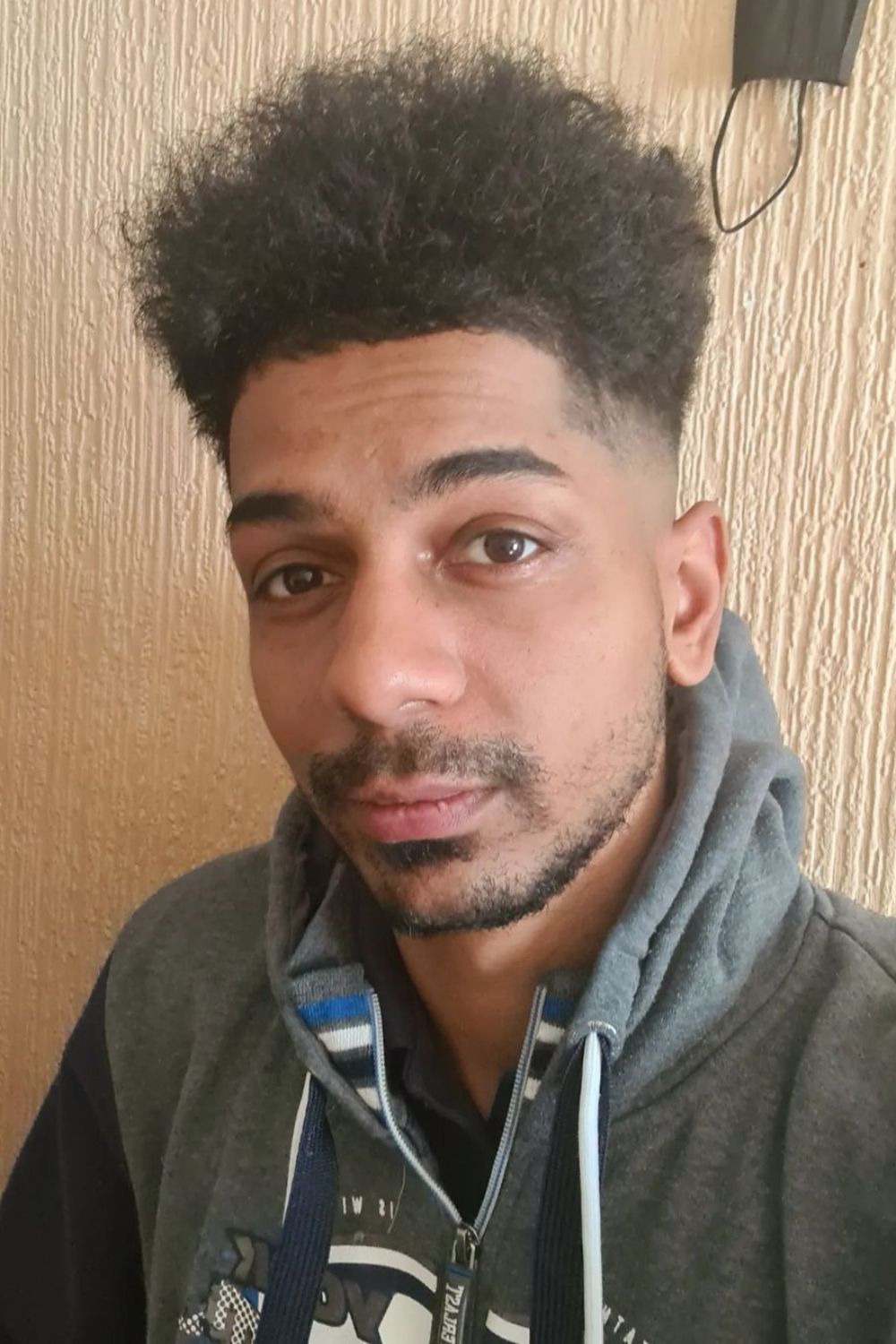 A man with a n Afro grown-out fade cut.