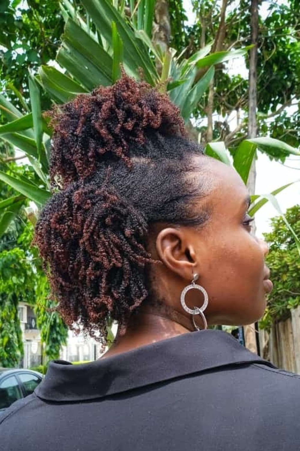 A woman with a half up half down 4C hairstyle.