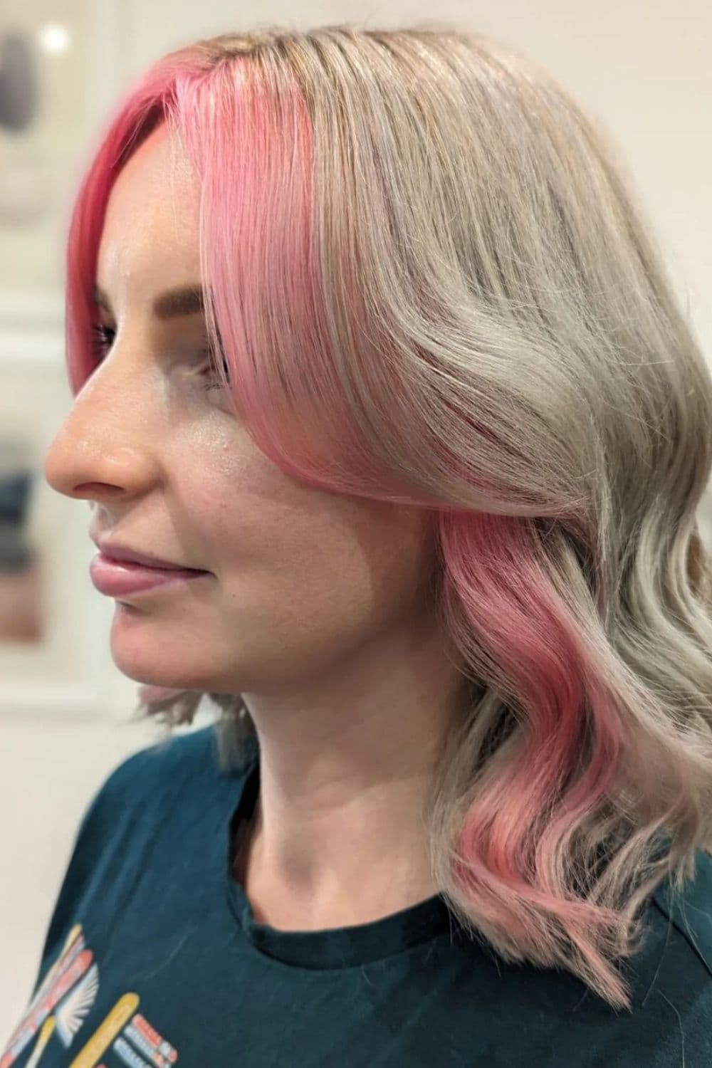 A woman with pink money pieces on silver hair.