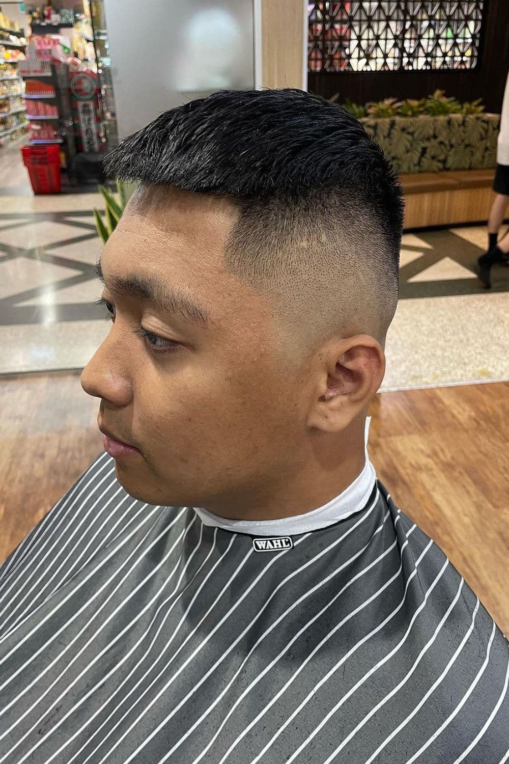 Side view of a man with a high skin fade.