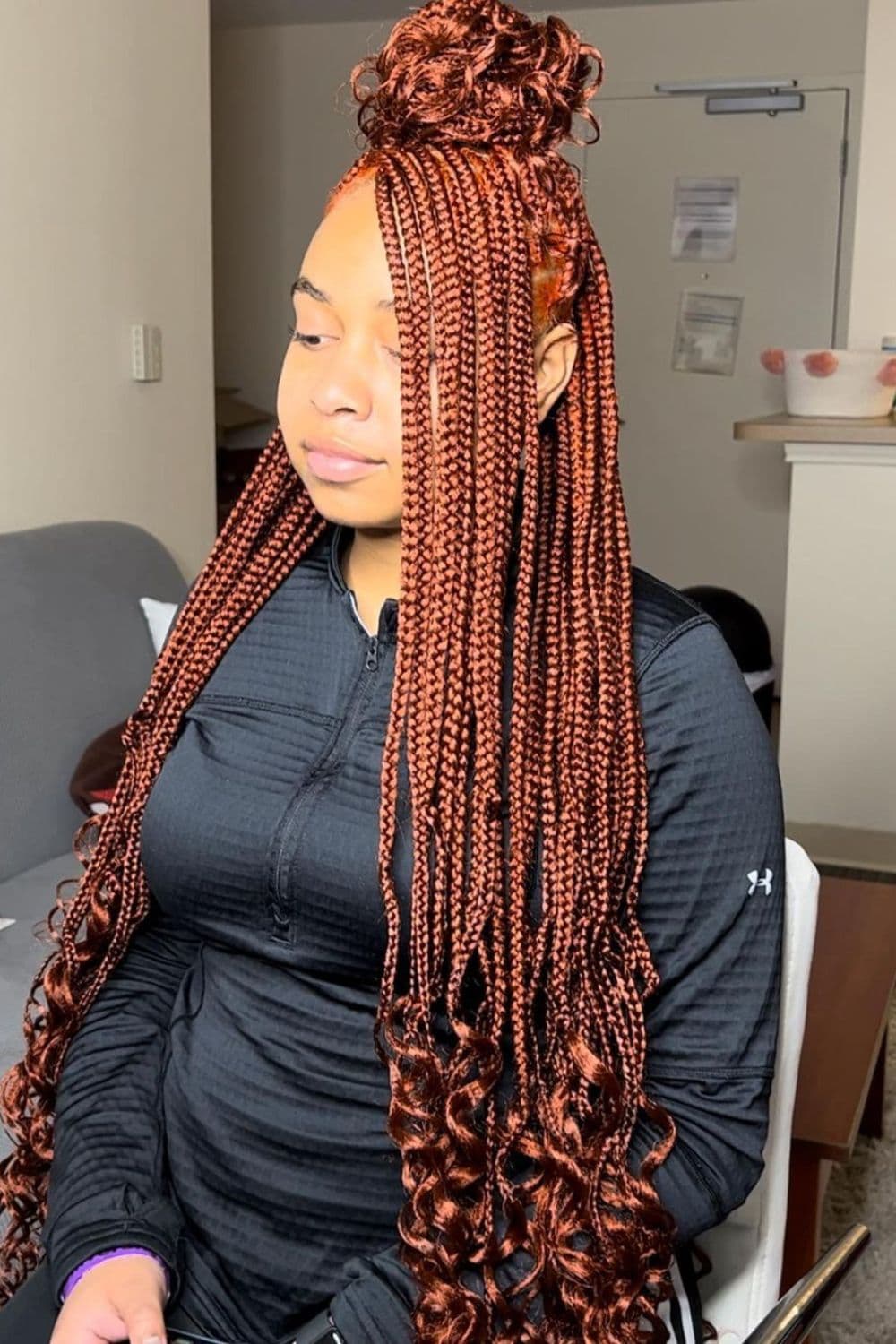 A woman with brown knotless crochet braids.