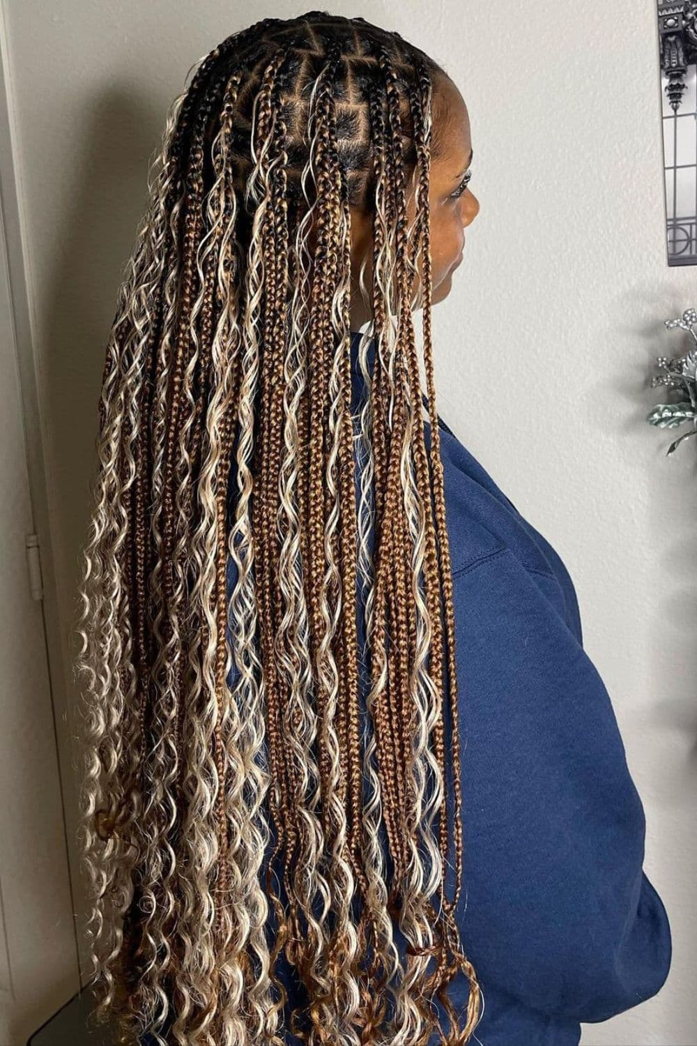 A woman with long brown and blonde knotless goddess braids.