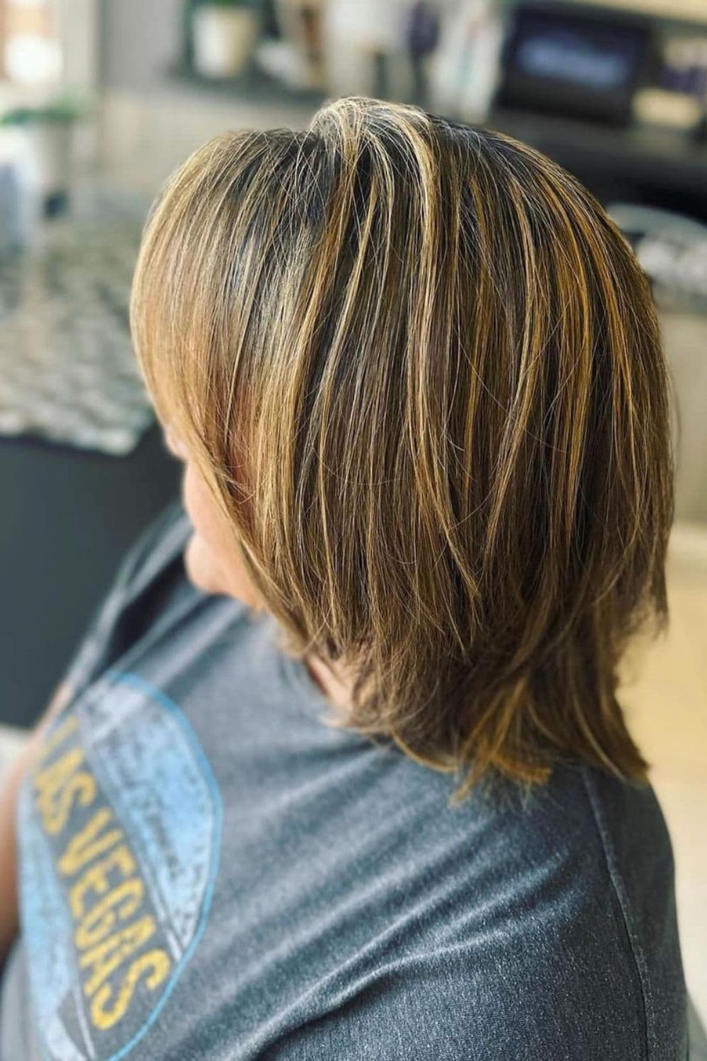 A woman with a layered shoulder-length balayage.